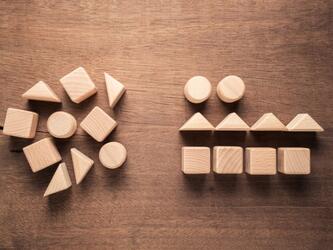 wooden blocks in assorted shapes coming together to form outline of person
